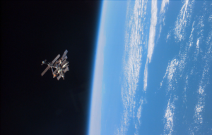 A satellite floating in space, Earth can be seen on the right of the photo.