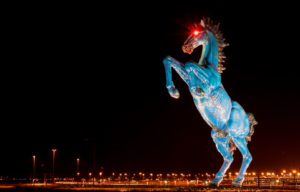 The "Mustang" sculpture at night.