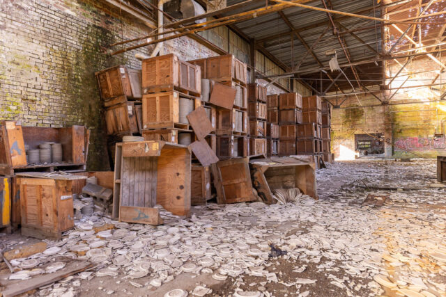 Broken pottery and stacked boxes in a warehouse.