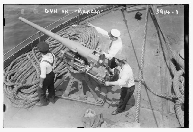 Three sailors manning an Ordnance QF Hotchkiss six-pounder deck gun