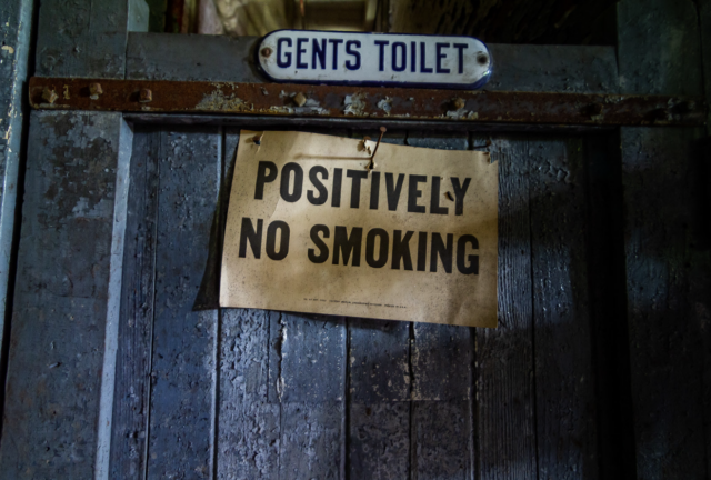 A sign on a washroom stall that reads "POSITIVELY NO SMOKING."