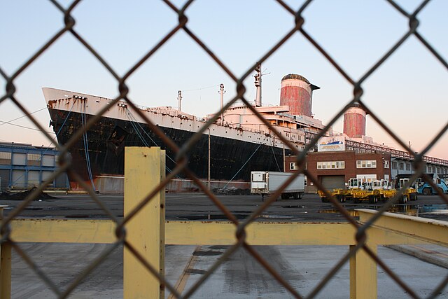 View of the SS United States through a chain-link fence