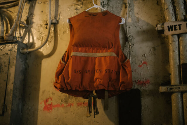 Life jacket hanging on a wall in a dimly-lit room