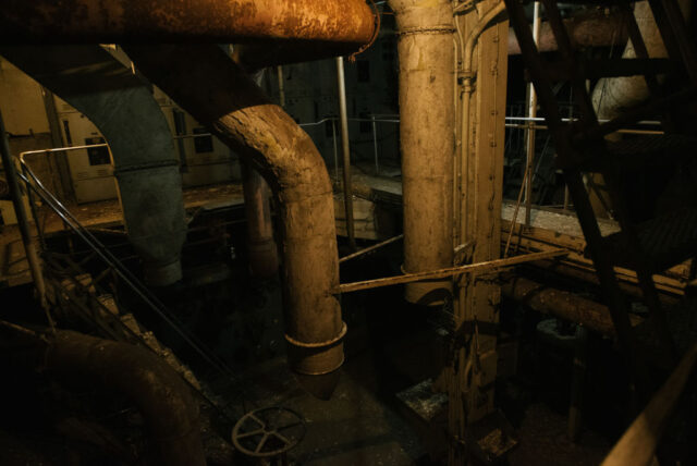 Rusted pipes in a dimly-lit room