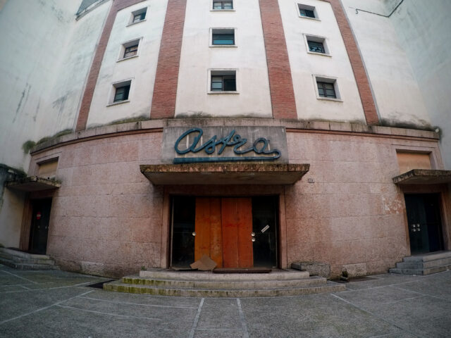 The exterior of an abandoned movie theater.