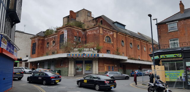 The exterior of an abandoned movie theater.