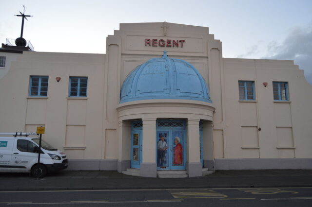 The exterior of an abandoned movie theater.