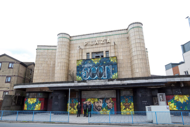 The exterior of an abandoned movie theater.