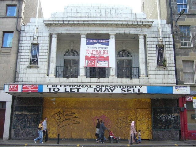 The exterior of an abandoned movie theater.