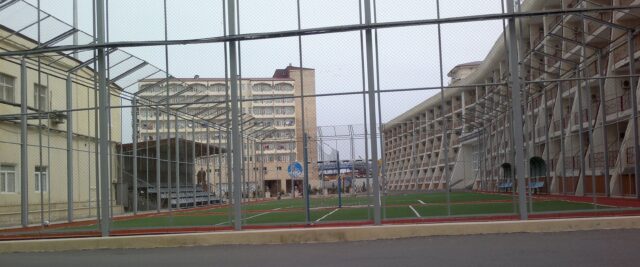 Soccer field surrounded by apartment buildings in Neft Dashlari