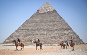 People on horseback moving past the Great Pyramid of Giza