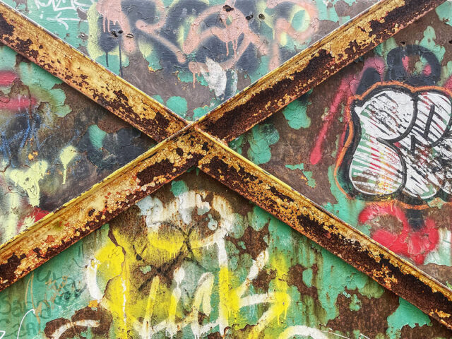 Close-up of graffiti on a rusty metal base