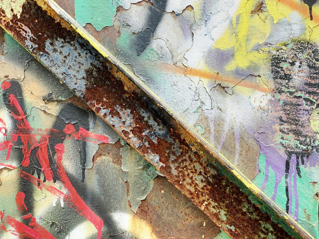 Close-up of graffiti on a rusty metal base