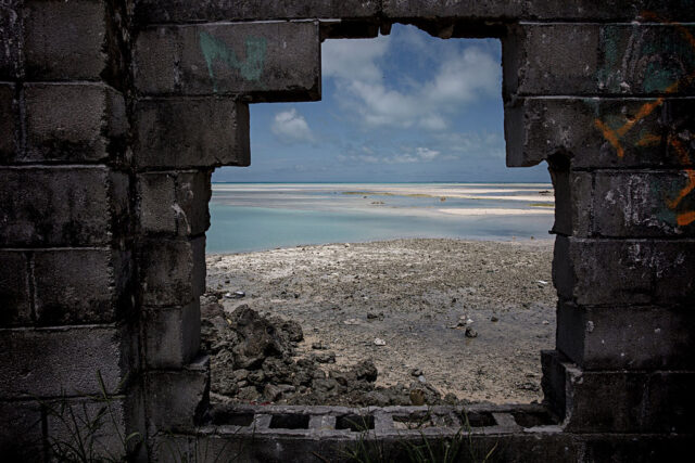 View of the ocean through a hole in a brick wall