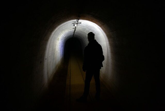 Man standing in a dark tunnel at the Ostwall Fortifications