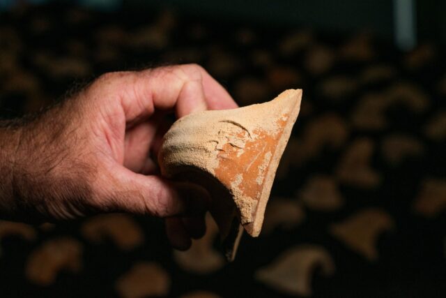 Hand holding a ceramic jar handle