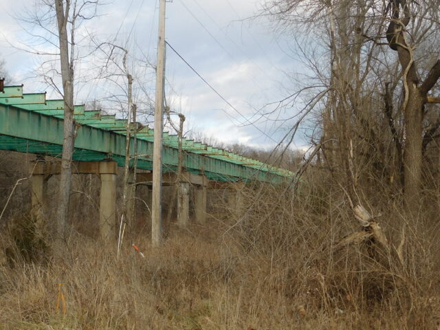 Railroad bridge running through a wooded area