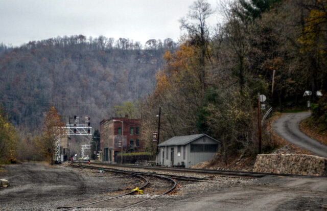 Buildings standing along the side of railroad tracks