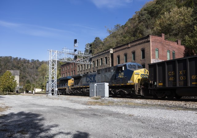 Train transiting past a brick building